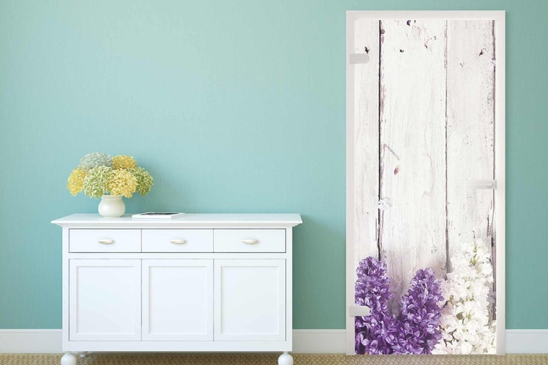 Ozdobné dvere s drevenými doskami a kvetinovým motívom vo svetlej miestnosti.