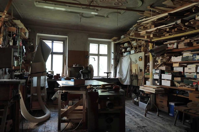 Dielňa s náradím, strojmi a skladmi dreva.