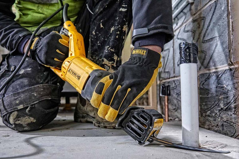 Pracovník reže rúrku pílou ocaskou DeWalt.