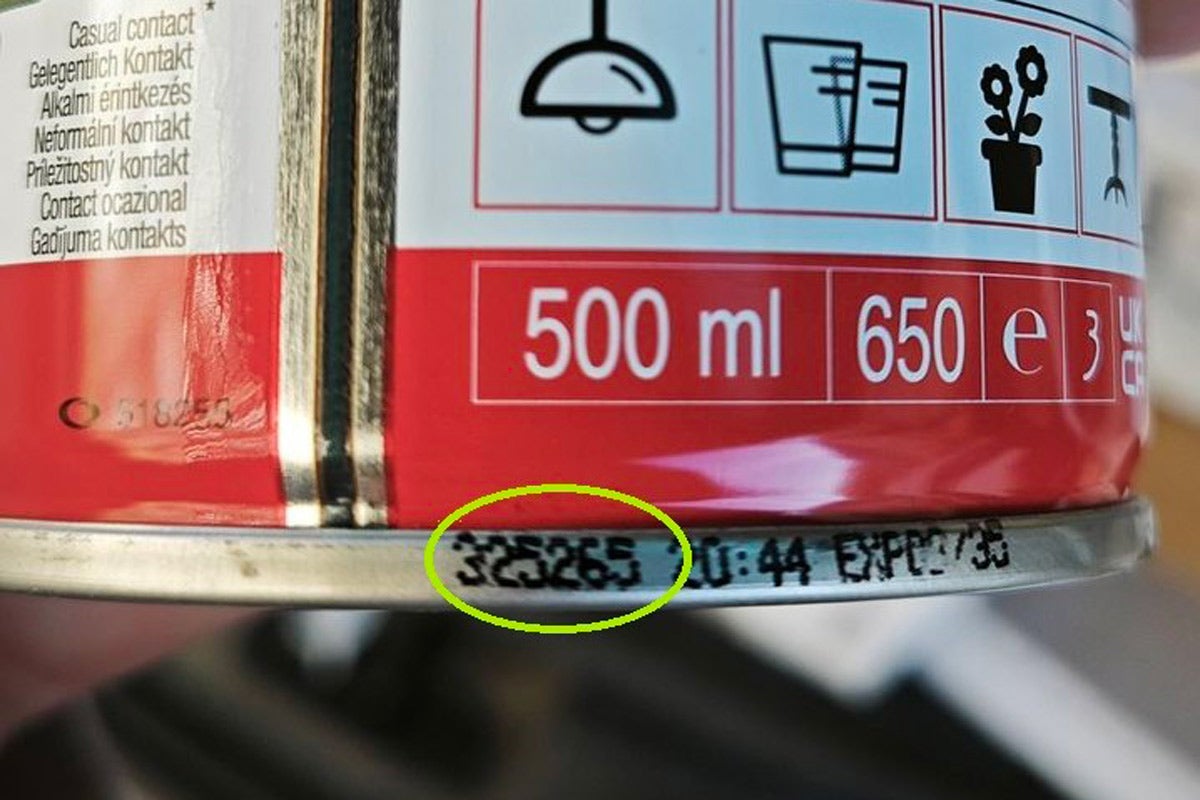 Detailný záber na plechovku s objemom 500 mililitrov so zameraním na číslo šarže a dátum spotreby na spodnom kovovom okraji.