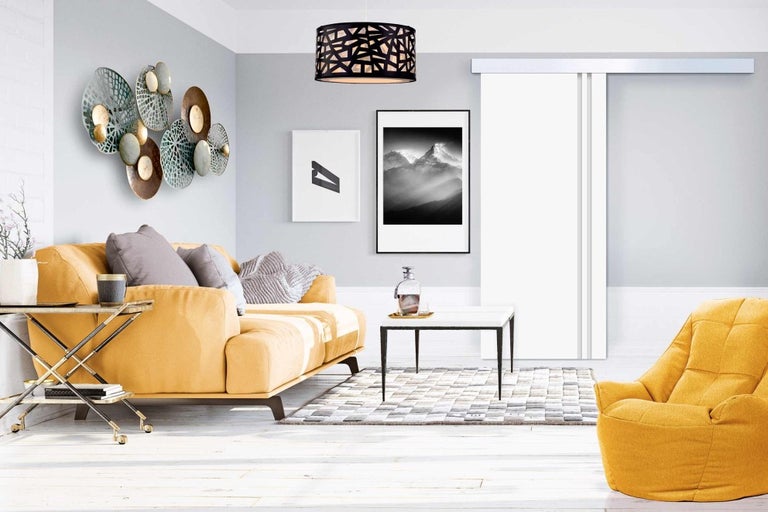 Obývacia izba s pohovkou, kreslom, konferenčným stolíkom, kobercom, nástennou dekoráciou, závesným svietidlom a posuvnými dverami