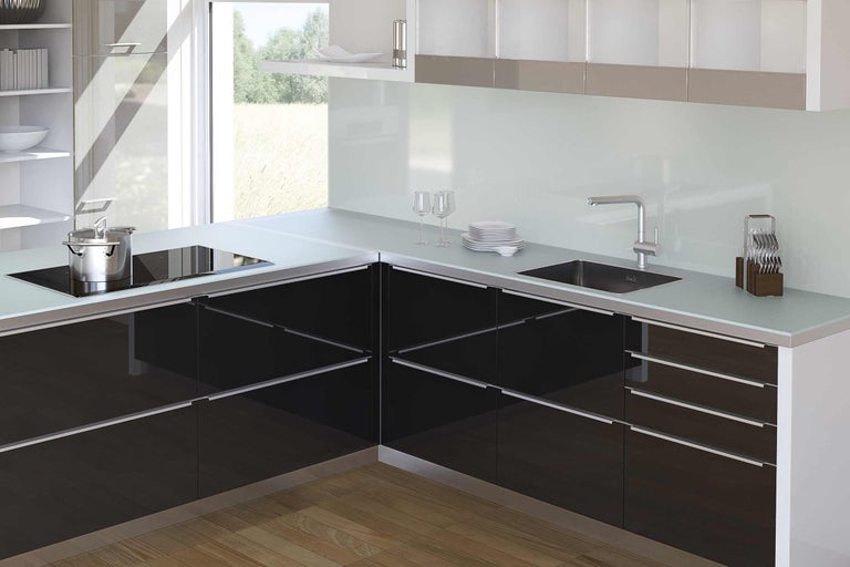 Moderná kuchyňa s čiernymi skrinkami, drezom a varnou doskou.