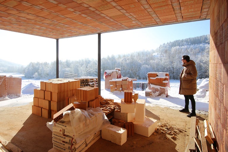 Stavenisko s tehlami a výhľadom na zasneženú krajinu