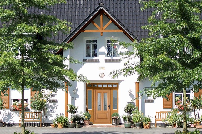 Pohľad na dom s vchodovými dverami, oknami a rastlinami