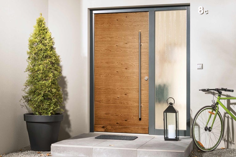 Moderné vchodové dvere s bočným dielom, štruktúrou dreva, nerezovou rukoväťou a dekoráciami