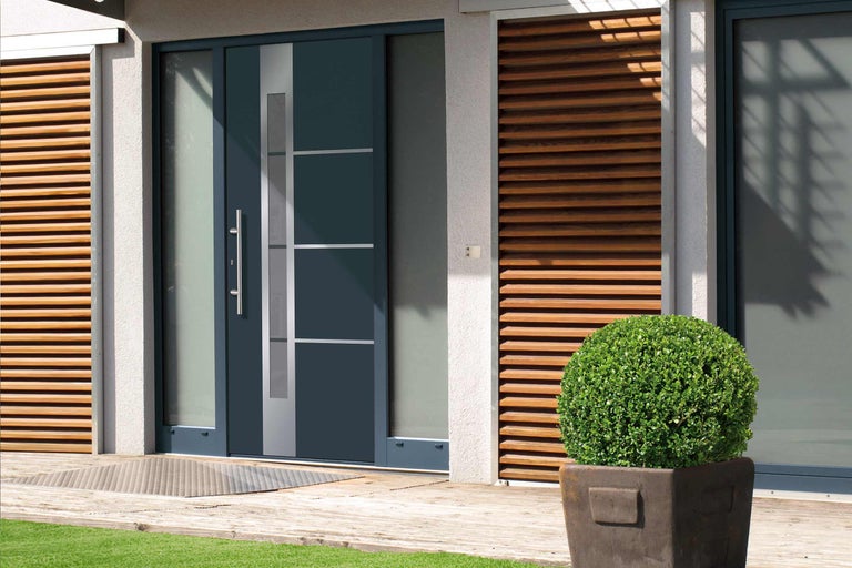 Moderné vchodové dvere so sklenenými prvkami a nerezovou kľučkou vo svetlom dome