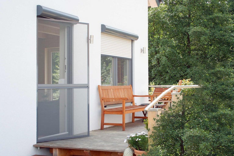 Fasáda domu s dverami proti hmyzu a roletami