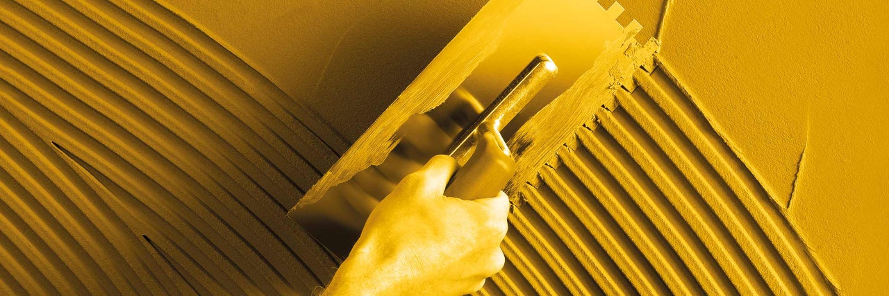 Nanášanie lepidla na obklady pomocou lyžice