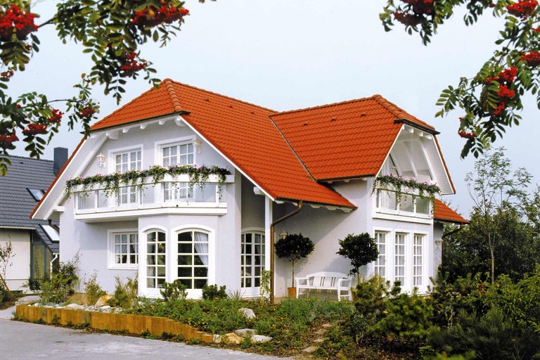 Rodinný dom s červenou škridlovou strechou a kvitnúcimi balkónmi
