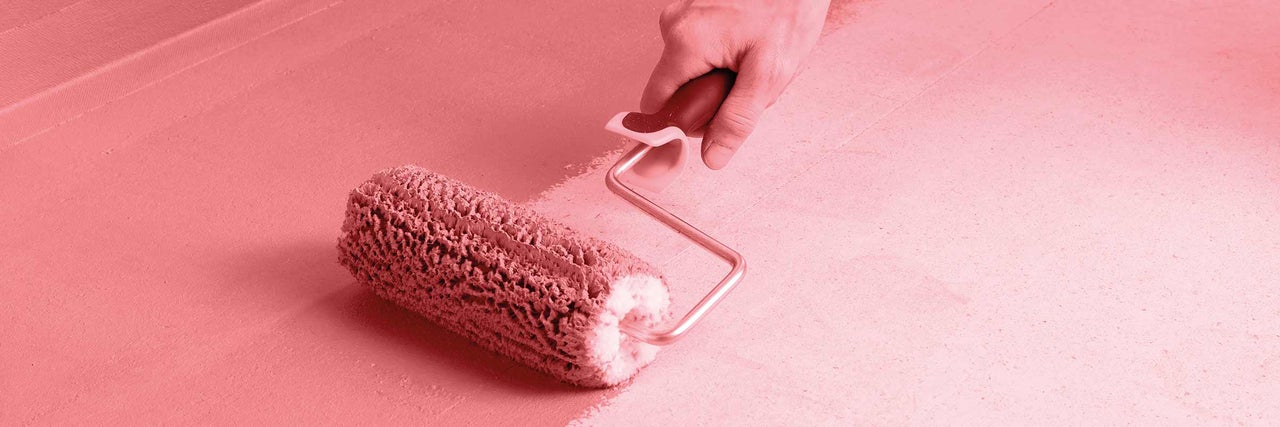 Osoba natiera povrch valčekom na farbu.