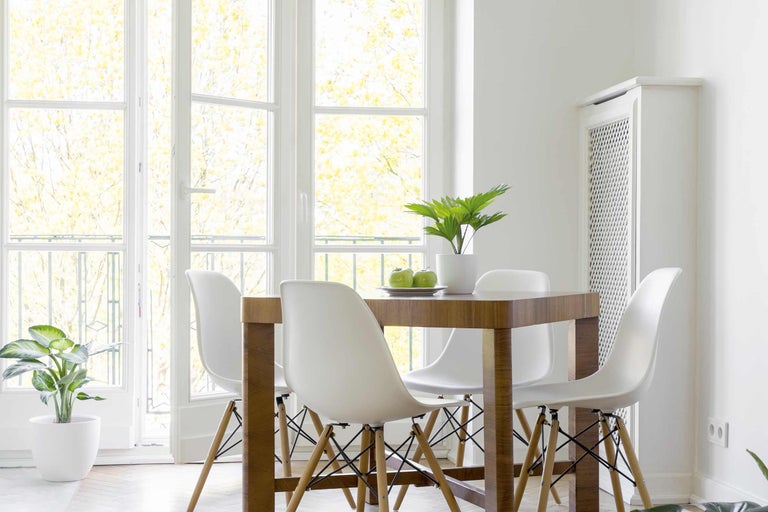 Svetlá jedáleň s dreveným stolom a bielymi stoličkami