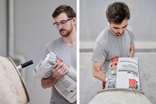 Muž sype betónovú zmes do miešačky na betón