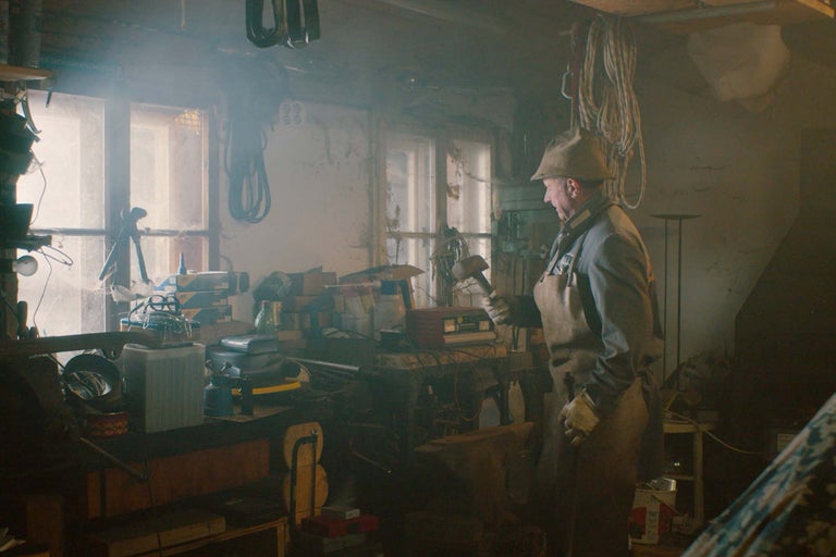 Dielňa s mužom v pracovnom odeve a náradím