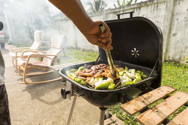 Grilovanie mäsa, cibule a papriky v záhrade.