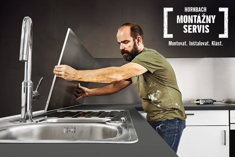 Muž inštaluje kuchynskú zástenu nad drezom, montážny servis Hornbach