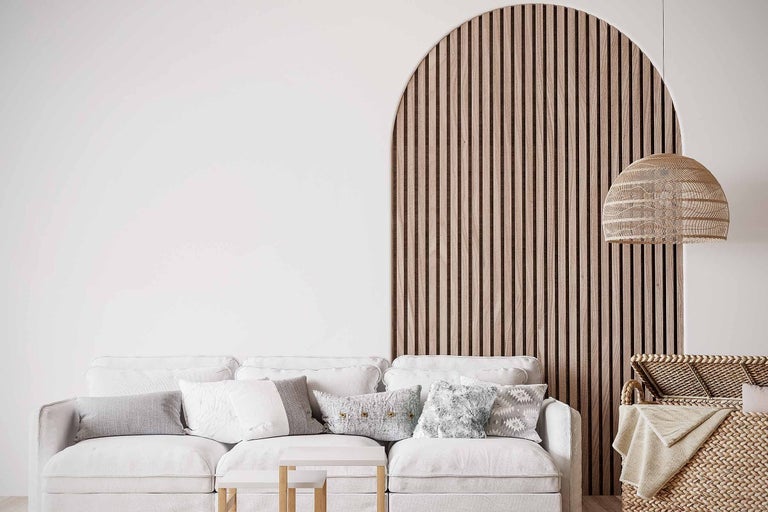 Obývacia izba s pohovkou, drevenými stenovými panelmi, lampou a košom