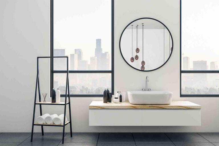 Moderná kúpeľňa s umývadlom, zrkadlom a regálom na uteráky pred veľkým oknom s výhľadom na mesto