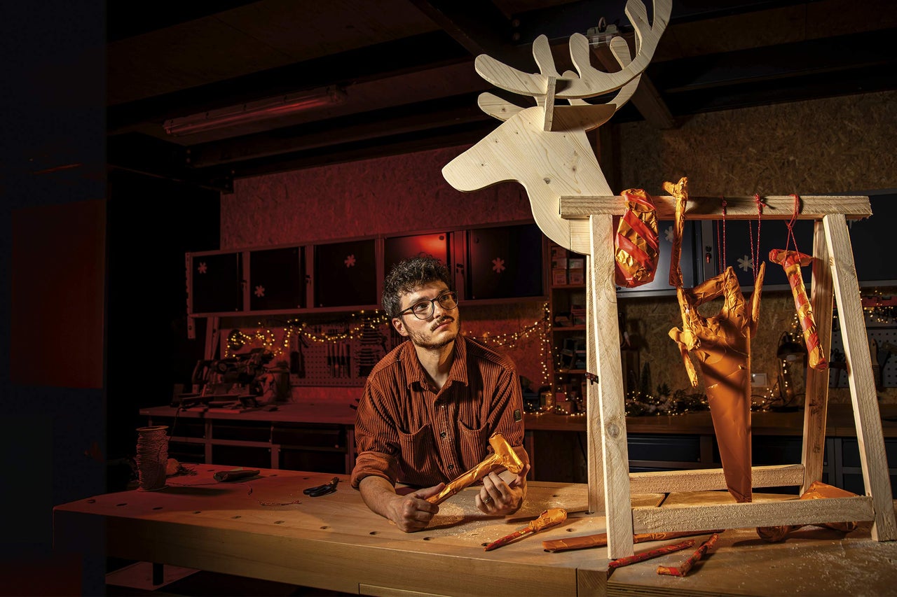 Dielňa s mužom, pracovný stôl, drevený sob a balené náradie