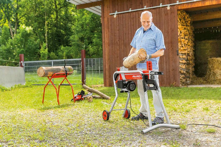 Muž štiepa drevo pomocou štiepačky dreva Al-ko vonku.