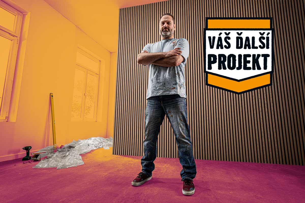 Remeselník s prekríženými rukami stojí pred stenou s dreveným obložením v rekonštruovanej miestnosti s logom Hornbach