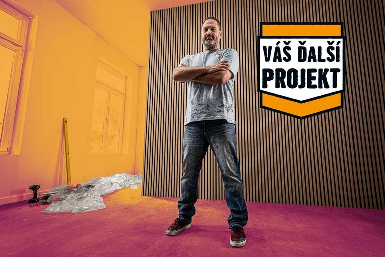 Remeselník s prekríženými rukami stojí pred stenou s dreveným obložením v rekonštruovanej miestnosti s logom Hornbach
