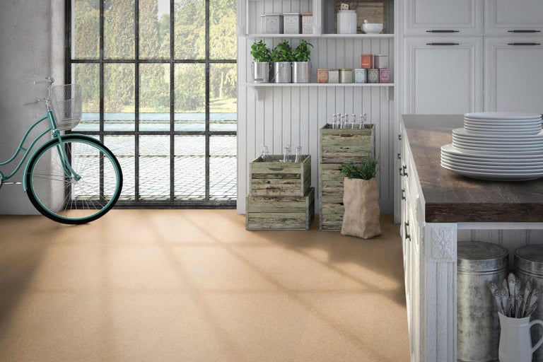 Korková podlaha vo svetlej miestnosti s oknom, bicyklom a kuchynskými prvkami.