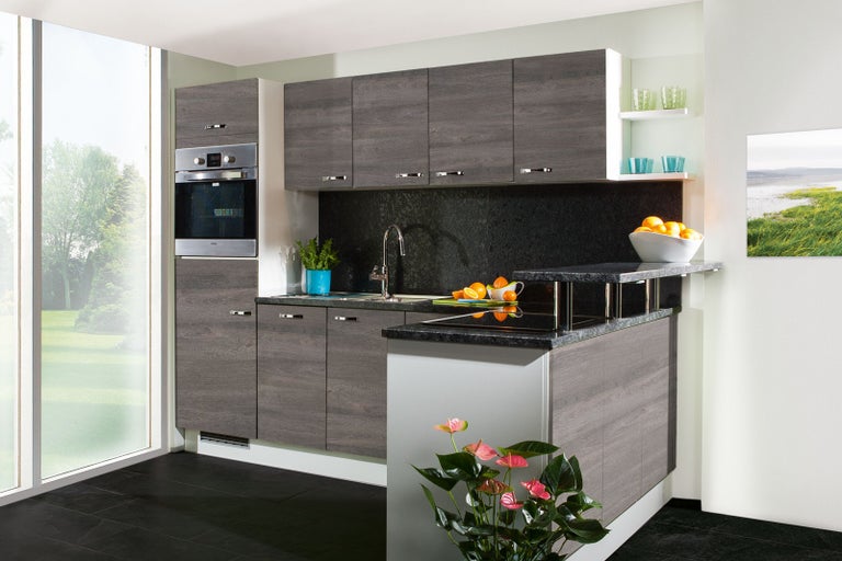 Moderná kuchyňa so sivými drevenými čelami, drezom, varnou doskou a vstavanou rúrou.