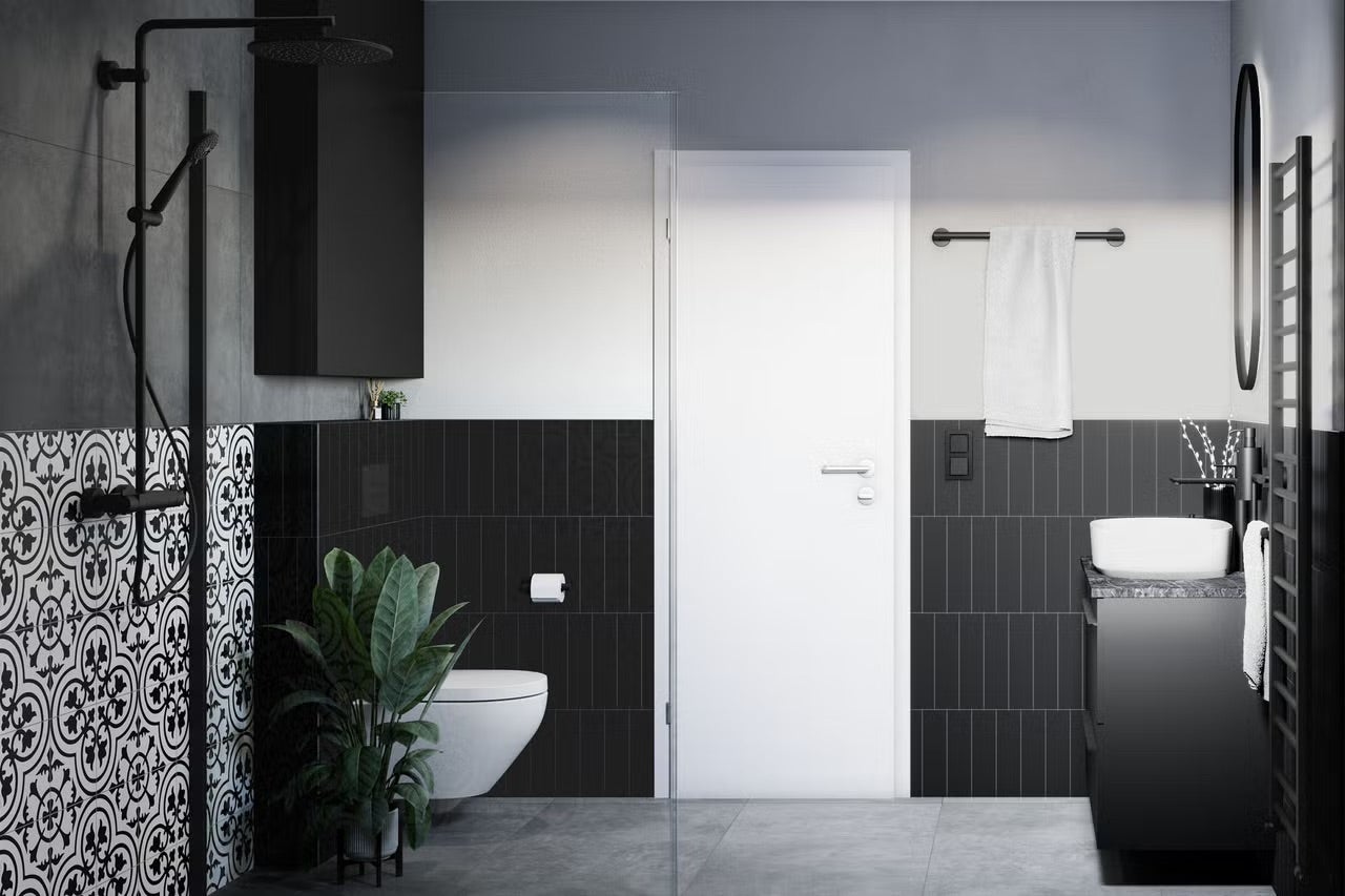 Moderná kúpeľňa so sprchou, umývadlom, toaletou a čiernymi dlaždicami