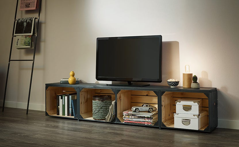 Obývacia izba s televízorom na nízkej doske vyrobenej z drevených debien, rebrík na noviny