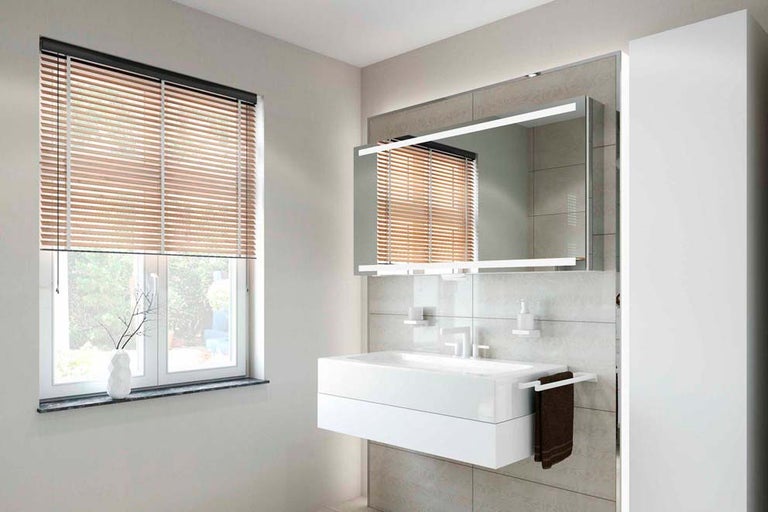 Moderná kúpeľňa s oknom, drevenými žalúziami, umývadlom a osvetleným zrkadlom