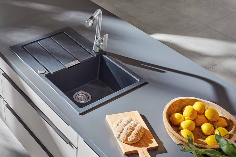 Kuchynský drez s odkvapkávacou plochou, batéria, chlieb a citrón