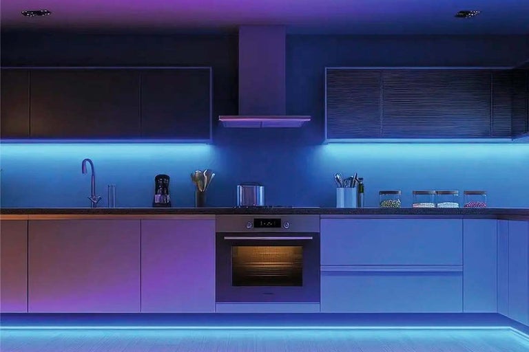 Moderná kuchyňa osvetlená LED pásikmi pod hornými skrinkami a na sokli v modrej a fialovej farbe