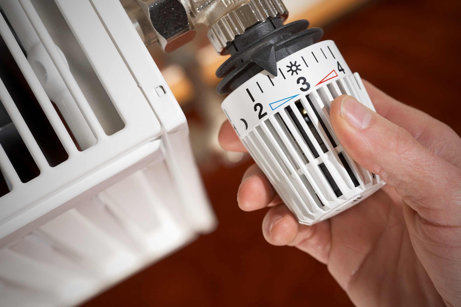 Detailný záber termostatickej hlavice radiátora ovládaného rukou