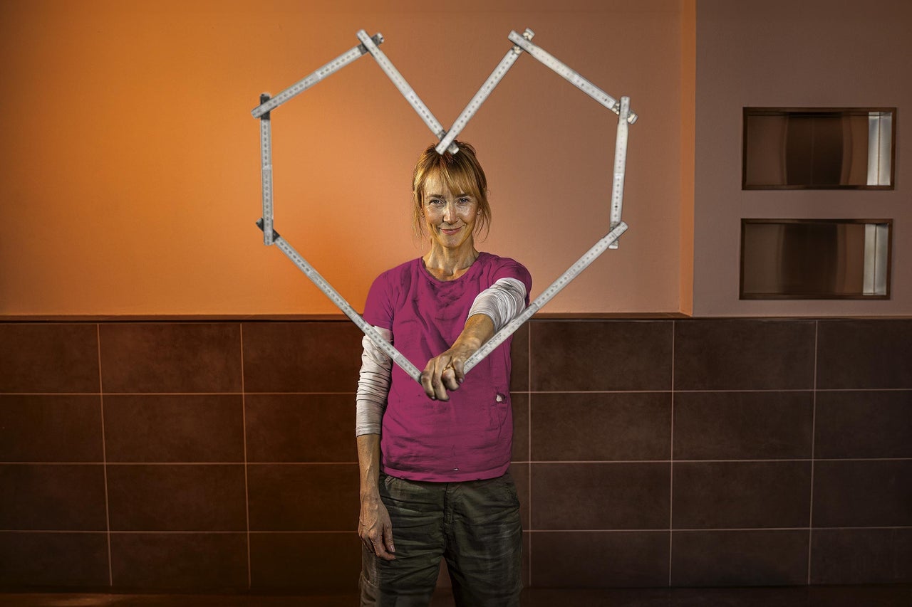 Žena drží skladací meter v tvare srdca.