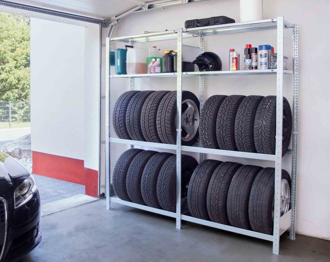 Regál v interiéri garáže s pneumatikami, kontajnermi a motocyklovou prilbou