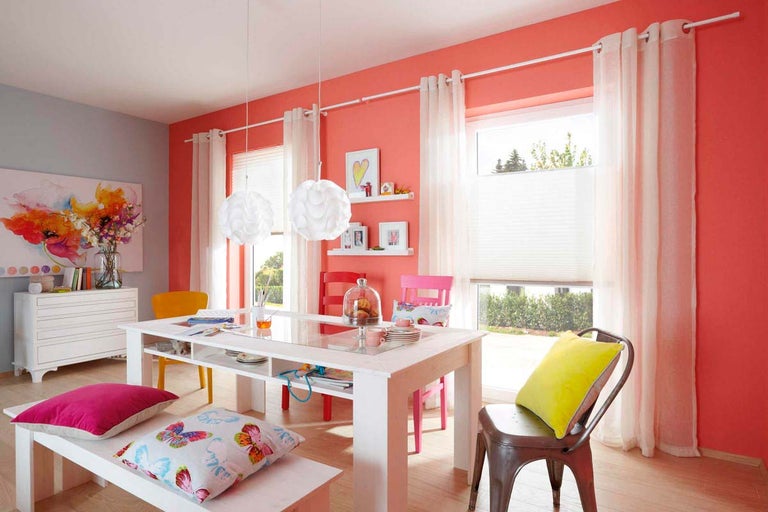 Svetlá jedáleň s jedálenským stolom, stoličkami, závesnými svietidlami a okennou dekoráciou