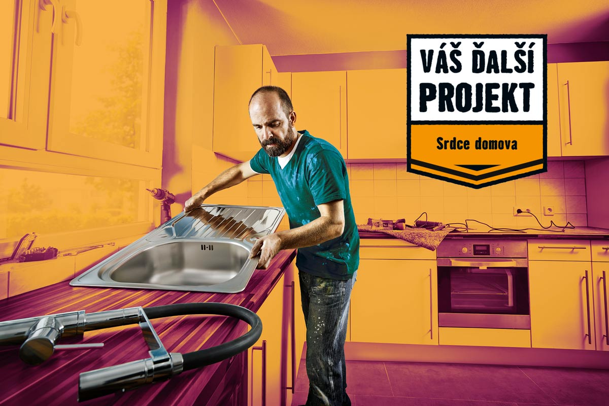 Muž inštaluje nerezový drez v kuchyni s textom 'Váš ďalší projekt, srdce domova'.