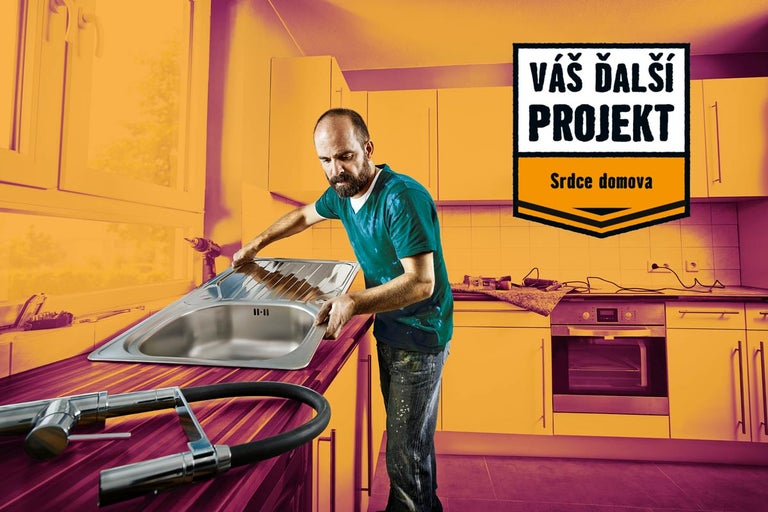 Muž inštaluje nerezový drez v kuchyni s textom 'Váš ďalší projekt, srdce domova'.