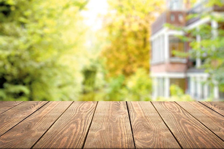 Drevená stolová doska s pozadím záhrady a domu