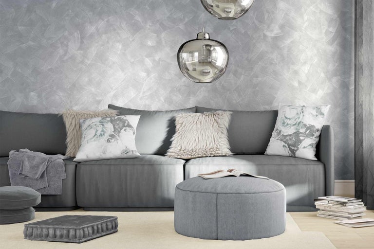 Obývacia izba so sivou pohovkou, vankúšmi a striebornou dekoráciou