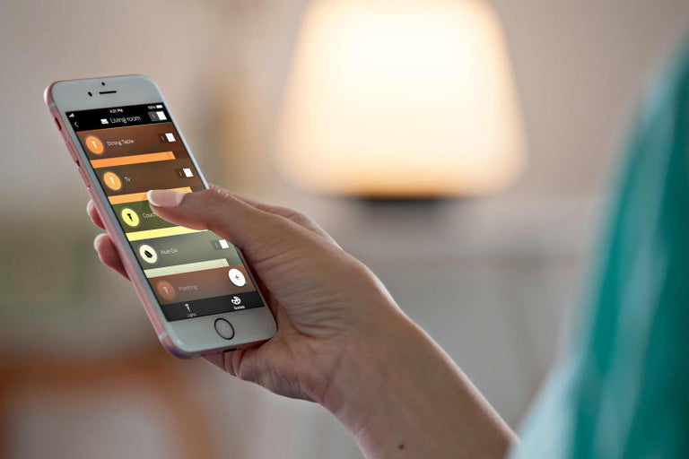 Osoba ovláda aplikáciu na ovládanie osvetlenia na smartfóne.