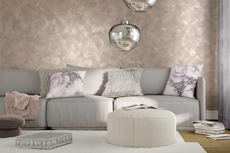 Obývacia izba so sivou pohovkou, vankúšmi, pufom a dekoratívnou úpravou stien