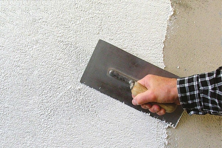 Nanášanie omietky na stenu pomocou lyžice