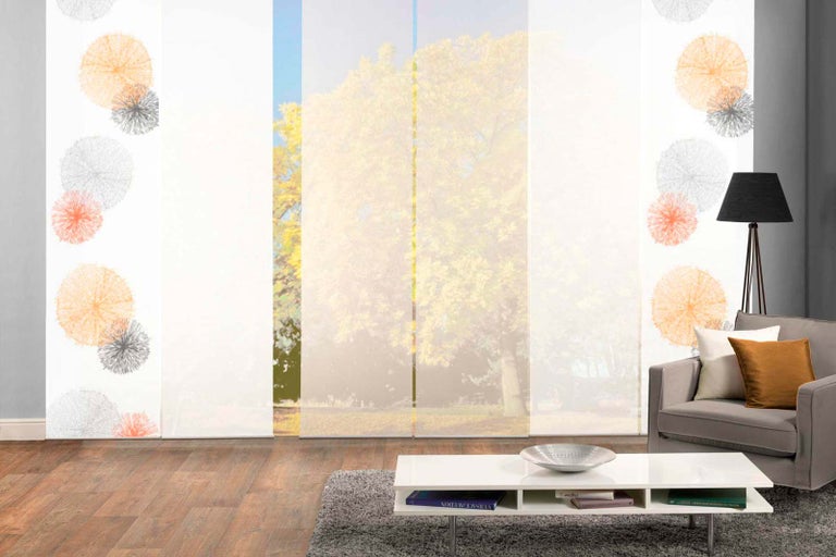Obývacia izba s posuvnými závesmi s kvetinovým vzorom pred oknom