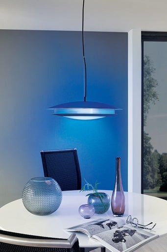Závesná lampa nad stolom s dekoráciami a časopisom