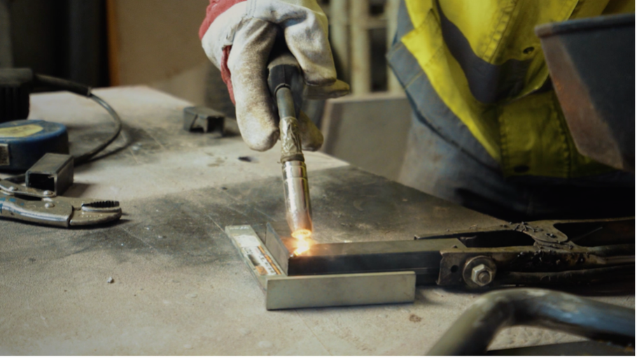 Zváranie kovu so zváračkou na pracovnom stole