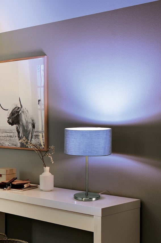 Dekoratívna stolná lampa s látkovým tienidlom na bielej komode