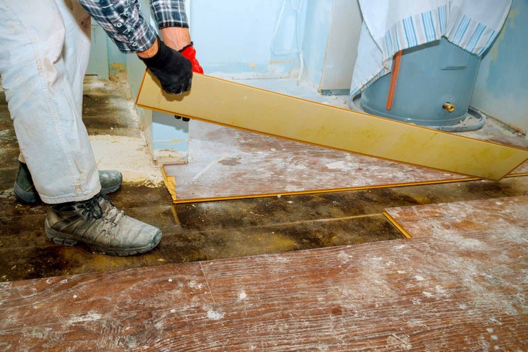 Remeselník kladie laminátovú podlahu v miestnosti.