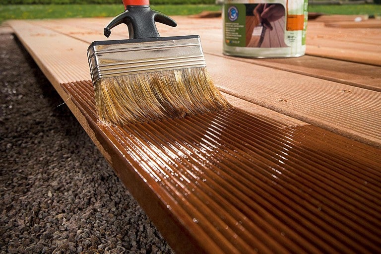 Natieranie drevenej terasy plochým štetcom a lazúrou na ochranu dreva