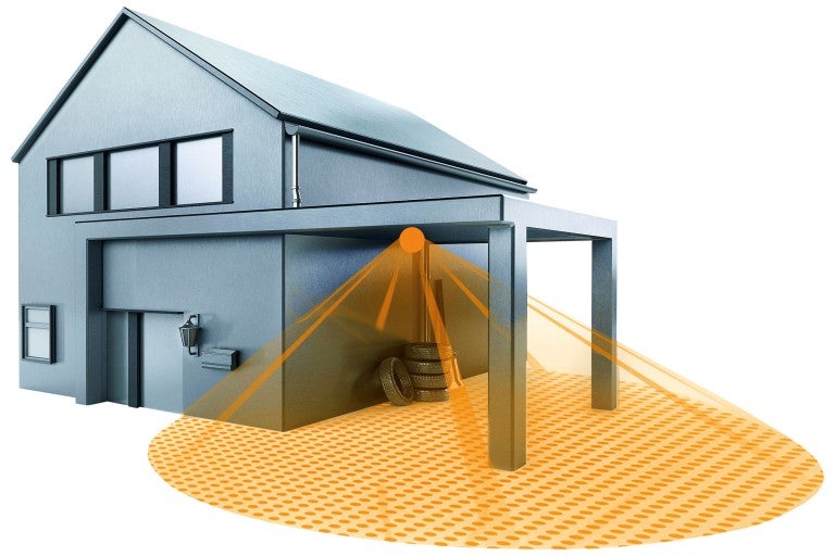 Dom s prístreškom pre auto a pohybovým senzorom, ktorý osvetľuje oblasť